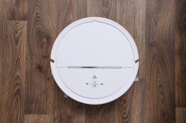 Tahta arka planda kablosuz elektrik süpürgesi, üst görünüm
