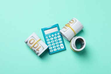 Bir rulo içinde bükülmüş para, bir hesap makinesi ile.