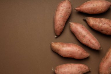 Kahverengi arka planda taze patates.