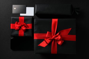 Siyah arka planda fiyonklu siyah hediye kutusu..