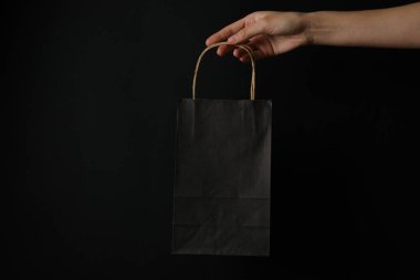 Siyah arka planda kağıt alışveriş torbası..