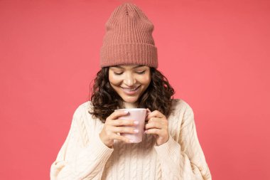 Kalın elbiseli, şapkalı, fincanlı bir kız..