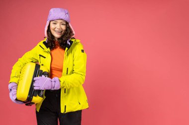 Bavullu, sıcak kayak takımı giymiş bir kadın..