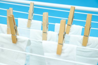 Kurutma makinesinde beyaz çoraplı ahşap mandallar.