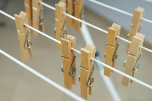 Close-up of wooden clothespins on a drying rack