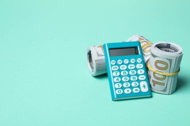 Bir rulo içinde bükülmüş para, bir hesap makinesi ile.