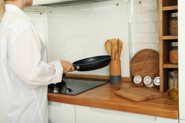 Genç bir kadın mutfakta kahvaltı hazırlıyor.