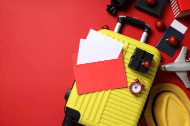 Bavul, hediye kutuları, kağıtlı zarf ve kırmızı arka planda şapka, metin için yer