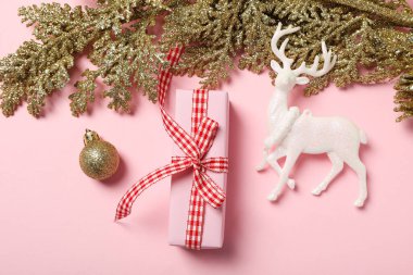 Pembe arka planda hediye kutusu ve yeni yıl süslemeleri, üst görünüm
