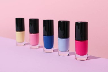 Pembe arka planda çok renkli tırnak cilası.