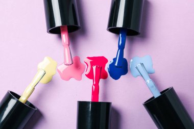 Arka planda kemikleri olan çok renkli ojeler.