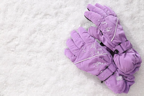Warm stylish ski gloves on white snow