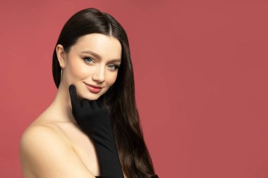 Kırmızı arka planda siyah eldivenli çekici kız.