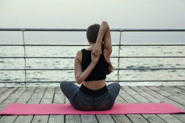 Yoga minderinde bir kadın Denizde ahşap zeminde