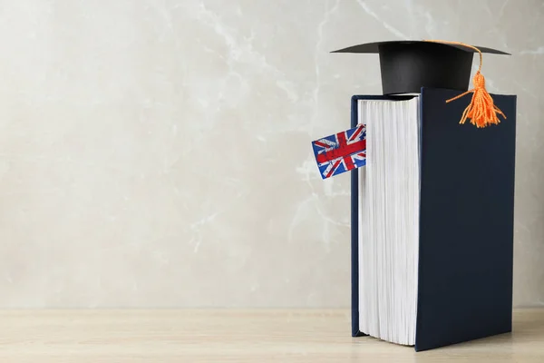 A book with a graduation cap and the flag of Great Britain