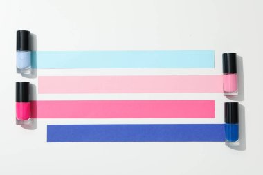 Beyaz arka planda çok renkli tırnak cilası.