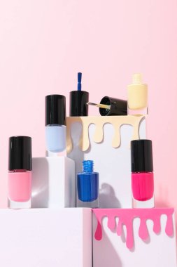 Açık arkaplanda beyaz küplerle birlikte pembe oje.