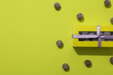 Kurdeleli ve yeşil arkaplanlı çikolata şekerleri, metin için boşluk