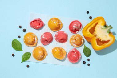 Mavi arka planda renkli mantı ve dolmalık biber.