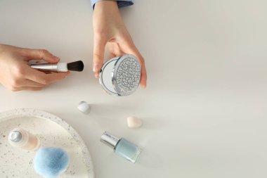 Kozmetik ürünleri ve aksesuarlar beyaz bir masada.