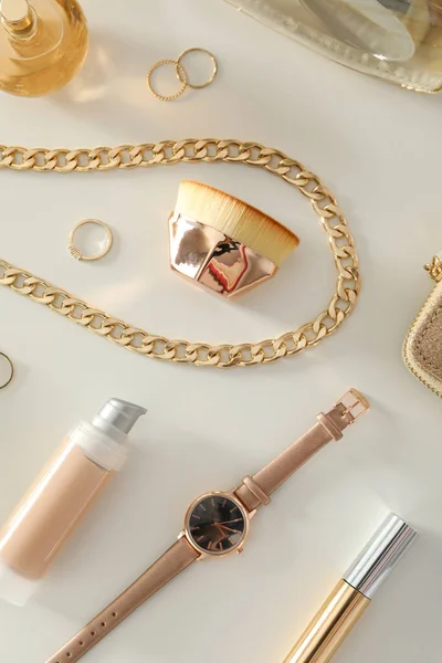 A watch, a gold chain and accessories are on the table