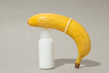 Kayganlaştırıcı, kondomda muz, gri arka planda..