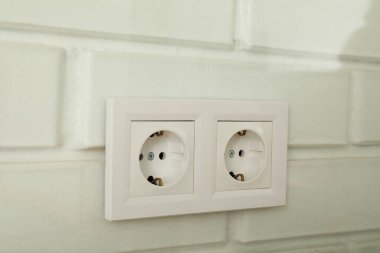Beyaz bir duvarda elektrik prizleri