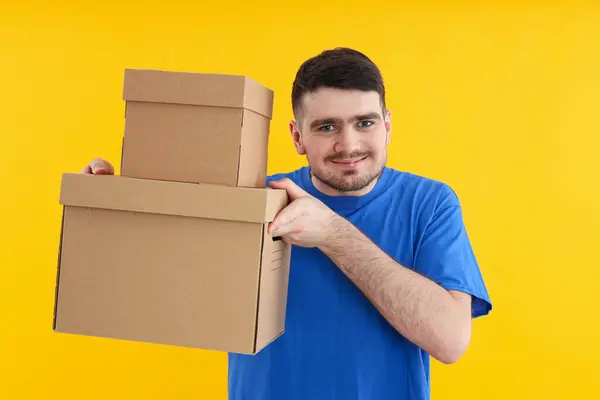Young attractive guy with cardboard boxes in hands