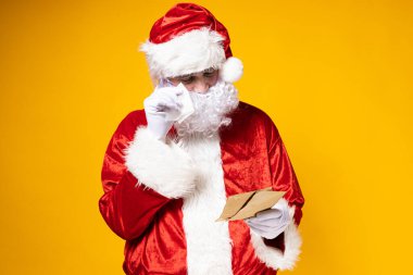 Noel Baba gözlerinde yaşlarla bir mektup okuyor..