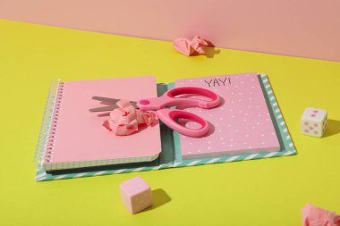 Not defteri, kağıtlar, makas ve zarlar sarı arkaplanda