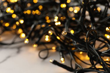 Mermer arka planda sarı ışıklı çelenk, kapat