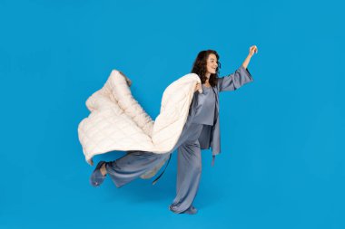 Mavi arka planda yastığı olan bir kız..