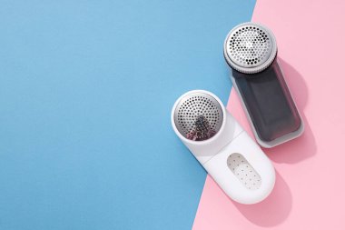 Elbiselerin üzerine kumaş traş makinesi, mavi arka plan..