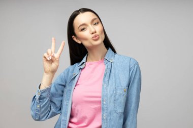 Gri arka planda poz veren çekici genç esmer.