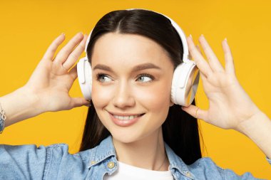 Kulaklıkla müzik dinleyen çekici genç bir kadın.