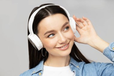 Kulaklıkla müzik dinleyen çekici genç bir kadın.