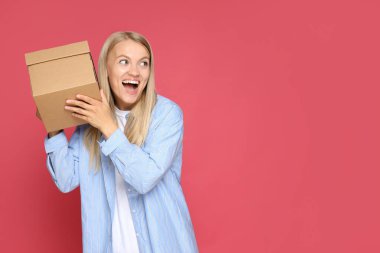 Elinde karton kutuyla çekici bir sarışın.