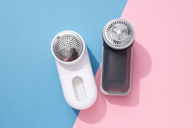 Elbiselerin üzerine kumaş traş makinesi, mavi arka plan..