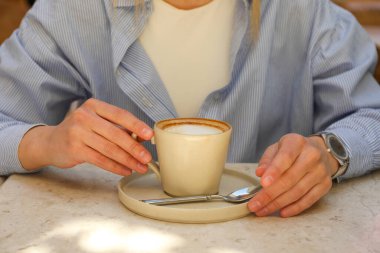 Masada bir fincan kahve ve kadın eli, yaklaşın.