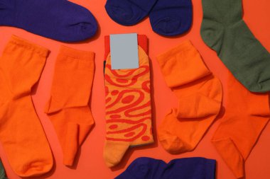 Turuncu bir arka planda, üzerinde parmak izi olan parlak çoraplar..