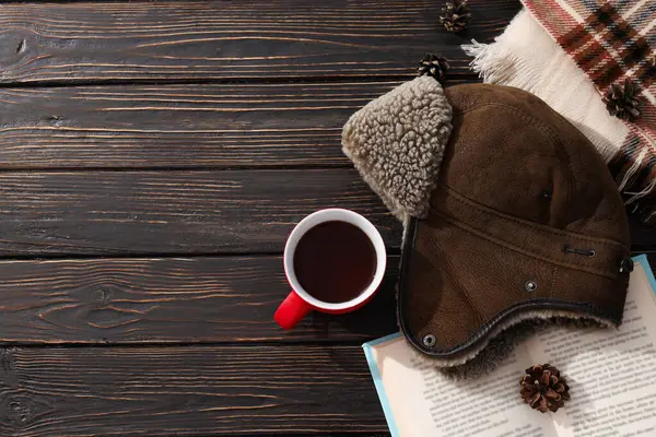 A warm winter hat with a book and tea