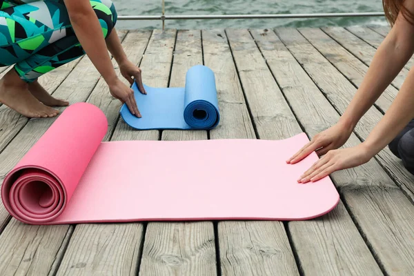 Yoga mats and two women on wooden floor