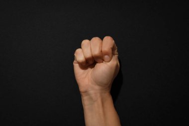 Siyah arka planda sıkılmış insan yumruğu