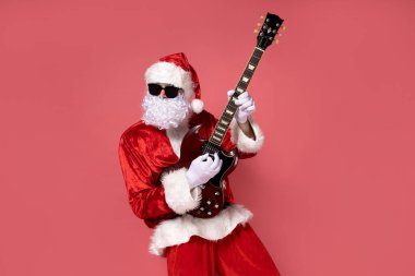Neşeli Noel Baba pembe arka planda gitar çalıyor..