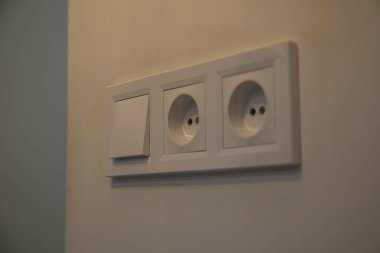 Duvarında kolye olan beyaz bir düğme.