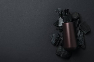 Koyu arkaplanda kömür bulunan doğal kozmetik ürünleri..