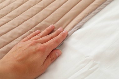 Yumuşak bir battaniyenin üzerinde bir kadın eli