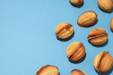 Mavi arka planda fındık şeklinde kurabiyeler.