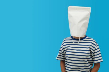 Kafasında beyaz kağıt torba olan kadın mavi arka planda, metin için boşluk