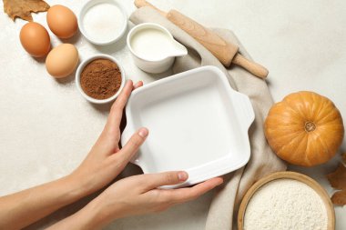 Fırın için beyaz bir tabak, yanında da balkabağı ve yumurta..